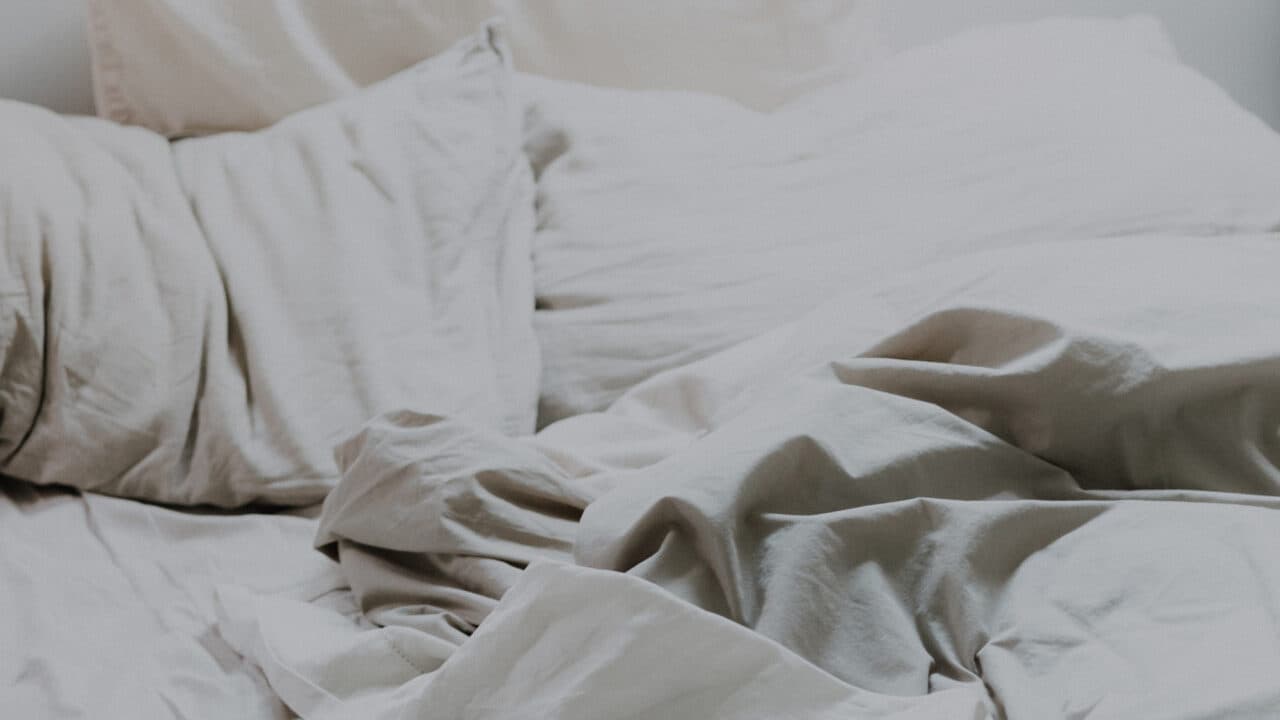 Uoppredd seng på varmt soverom